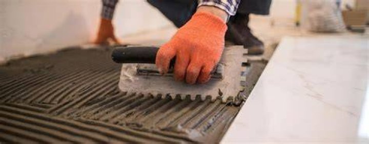 What is the correct way to apply thinset with a trowel?